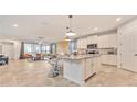 Open-concept kitchen with white cabinets, a quartz island, and a seamless transition to the living area at 2114 Fleming Mist Pl, Kissimmee, FL 34747