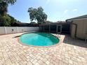 Backyard view of a beautiful in-ground pool with brick pavers and white fencing at 2151 Conifer Ave, Winter Park, FL 32792