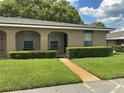 Inviting single-story home with a well-kept lawn leading to the entrance walkway at 228 Everest Pt # 108, Casselberry, FL 32707