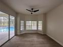 Bright room with wood floors, three large windows, and view of screened-in pool area at 2313 Park Village Pl, Apopka, FL 32712