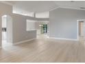 Open-concept living space with sleek hardwood floors and modern architectural details to adjoining rooms at 2360 Brewerton Ln, Orlando, FL 32824