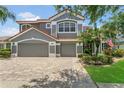 Lovely home with a three-car garage and brick driveway, complemented by verdant landscaping at 2388 Baronsmede Ct, Winter Garden, FL 34787