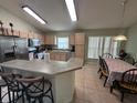 Cozy eat-in kitchen with breakfast bar, stainless steel appliances, and tile flooring at 2515 La Jolla Trl, Kissimmee, FL 34747