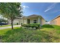 Charming single-story home featuring a manicured lawn and green shrubbery along the front at 264 Milestone Dr, Haines City, FL 33844