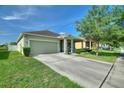 Inviting one-story home with a neutral color palette, two-car garage, and a well-kept front yard at 264 Milestone Dr, Haines City, FL 33844