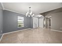 Bright, open living room showcasing tile floors, crown molding and a decorative chandelier at 2725 White Magnolia Loop, Clermont, FL 34711