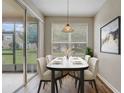 Bright dining area with a modern table and chairs, stylish light fixture, and sliding door access to the patio at 2763 Metro Sevilla Dr # 103, Orlando, FL 32835