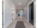 Elegant hallway with gray walls and white trim, tiled floors, and decorative wainscoting leading into home at 2816 Simile St, Kissimmee, FL 34746