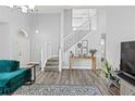 Bright living room featuring wood-look floors, stairs, and modern decor at 38 Jett Loop, Apopka, FL 32712