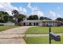 A view of the home with a long driveway, green lawn, mature trees and mailbox at 4217 Ilene Ct, Orlando, FL 32806