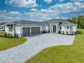 Beautiful home with a three-car garage, paver driveway, and manicured lawn at 4266 La Salle Ave, St Cloud, FL 34772