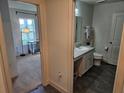 Bathroom featuring a vanity with storage, modern fixtures, and tile flooring adjacent to a bedroom at 4564 Orchard Grove Rd, St Cloud, FL 34772