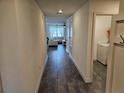 Inviting hallway leading to a bright living area, with stylish tile flooring and access to the laundry room at 4564 Orchard Grove Rd, St Cloud, FL 34772