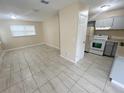 Open living room with neutral paint, and tile flooring, seamlessly connected to the kitchen at 4631 America St, Orlando, FL 32811