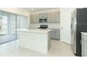 Kitchen with stainless steel appliances, island, and grey cabinets at 4917 Bluebell Ct, Lake Hamilton, FL 33851