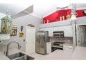Bright kitchen featuring stainless steel appliances, a corner sink, white cabinets, and eye-catching decor at 6011 Country Walk Ln, Winter Haven, FL 33880