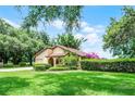 Charming single-story home with lush front yard and landscaping with green grass and mature trees at 6301 Parson Brown Dr, Orlando, FL 32819