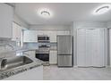 Bright kitchen featuring stainless steel appliances, modern fixtures, and sleek white cabinetry at 750 Olympic Cir # D1, Ocoee, FL 34761