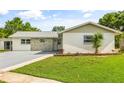 Charming single-story home boasting a metal roof and a lush, green lawn at 955 Tomes Ct, Orlando, FL 32825