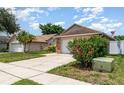 Nice single-story home with a two-car garage, a beautiful hibiscus bush, and a well-kept lawn at 11715 Sindlesham Ct, Orlando, FL 32837