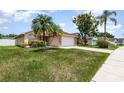 Inviting single-story home with palm trees, a well-maintained lawn, and a two-car garage at 11715 Sindlesham Ct, Orlando, FL 32837