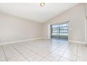 Bright living room featuring neutral walls, tile flooring, and sliding glass doors to the lanai at 11715 Sindlesham Ct, Orlando, FL 32837