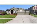 Attractive single-story home with lush landscaping and a spacious driveway at 13478 Summer Rain Dr, Orlando, FL 32828