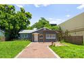Charming gray house boasts a brick walkway and lush landscaping at 1921 Dartmouth Ave, Winter Park, FL 32789