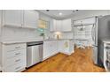 Bright kitchen featuring white cabinets, stainless steel appliances, granite countertops, and hardwood flooring at 1930 Aster Dr, Winter Park, FL 32792