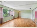 Well-lit living room featuring hardwood floors, large windows, and access to an enclosed porch at 2020 Cocos Ct, Winter Park, FL 32792