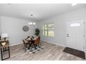 Modern dining room with stylish chandelier, wood-look flooring, and a view to the front yard at 2305 Ascot Ave, Orlando, FL 32833