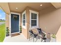 Charming covered porch with seating, decorative plants, and a welcoming front door at 3279 Canna Lily Pl, Clermont, FL 34711