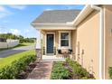 Cozy covered front porch with seating area, manicured landscaping, and a welcoming entrance at 3279 Canna Lily Pl, Clermont, FL 34711