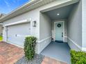 Inviting covered front entrance with brick accents and a stylish light blue door with a decorative wreath at 3849 Kimbolton Way, Sanford, FL 32773