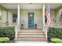 Inviting front porch with brick steps, a blue front door, and charming decor with an American flag waving proudly at 4509 Belkin Ct, Orlando, FL 32814