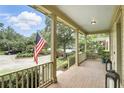 Spacious front porch with beautiful brick flooring, ample seating area and views of the well-manicured front yard at 4509 Belkin Ct, Orlando, FL 32814
