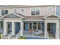 Beautiful townhome exterior showcasing blue and gray tones, a covered porch and manicured landscaping at 452 Diamond Dove Cv, Winter Springs, FL 32708