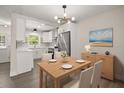 Modern dining area with stainless steel appliances, modern lighting, and white cabinets at 4714 Abaca St, Orlando, FL 32808