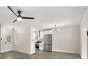 Open-concept kitchen with stainless steel appliances, white cabinets, and modern lighting at 4714 Abaca St, Orlando, FL 32808