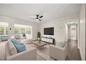 Bright living room featuring hardwood floors, a ceiling fan, and modern furniture with light blue accents at 4714 Abaca St, Orlando, FL 32808