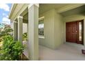 Inviting covered front porch with modern columns and a stylish entryway at 5226 Mahogany Dr, Mount Dora, FL 32757