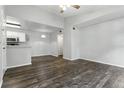 Bright living room featuring wood floors, neutral paint, and a ceiling fan next to a half wall kitchen at 5263 Images Cir # 306, Kissimmee, FL 34746