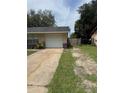 View of the driveway, one car garage, a lawn, and a wooden fence bordering the property at 6308 Stanwin Dr, Apopka, FL 32712