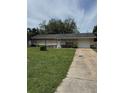 Single story home with well kept lawn, single car garage, and a tidy landscape with a tree in the front at 6308 Stanwin Dr, Apopka, FL 32712