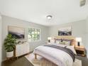 Bright bedroom featuring a queen bed, modern dresser, and view to the outdoors from a large window at 6740 Odoniel W Loop, Lakeland, FL 33809
