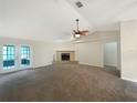 Spacious living room with a brick fireplace, ceiling fan, and access to the patio at 6740 Odoniel W Loop, Lakeland, FL 33809