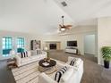 Bright living room featuring stylish furniture, a fireplace, and a ceiling fan at 6740 Odoniel W Loop, Lakeland, FL 33809