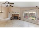 Spacious living room with tile flooring, fireplace, and large windows overlooking the backyard at 7263 Spring Villas Cir, Orlando, FL 32819