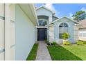 Close-up of the light blue home's elegant front entrance, accented with a tiled walkway at 7952 Oakstone Ct, Orlando, FL 32822