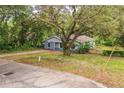 View of the home and a sprawling front yard shaded by mature trees at 1212 N Hudson St, Orlando, FL 32808